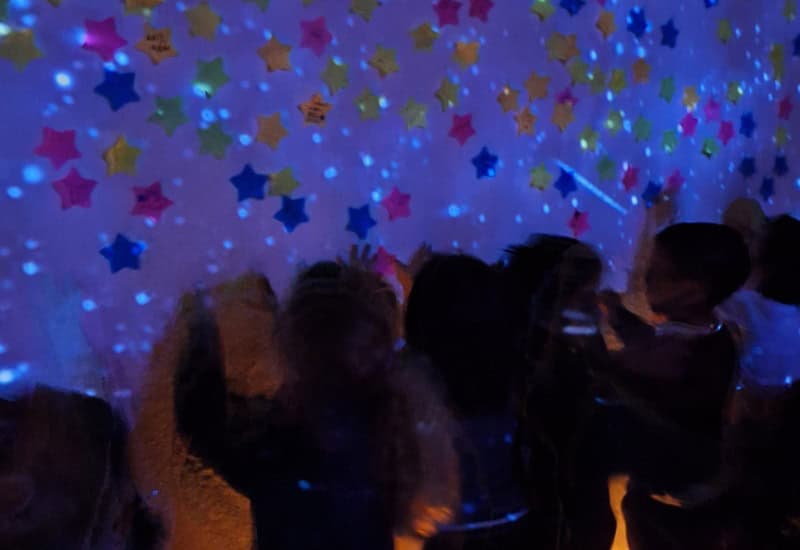 Alumnos experimentando con luces y colores estrellados en el espacio multisensorial de Educación Infantil del centro.